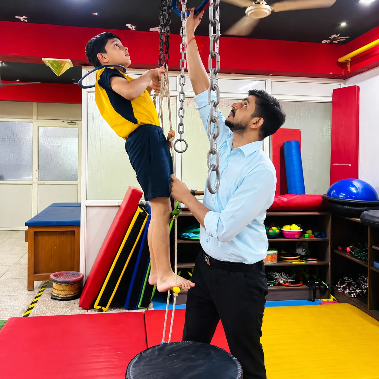 A child climbing a rope ladder with an OT Cloud occupational therapist.